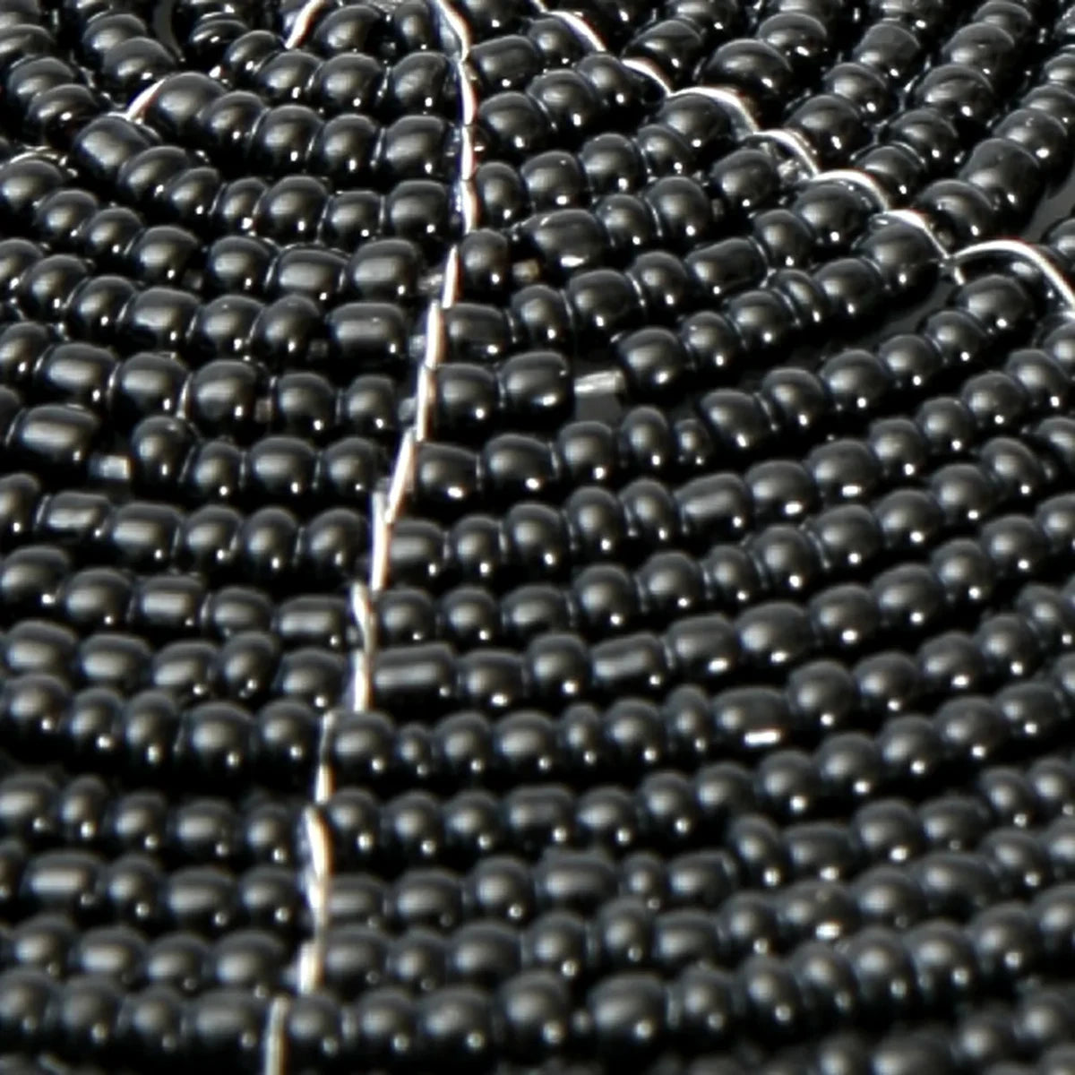 Detail van de zwarte kralen van een ronde onderzetter