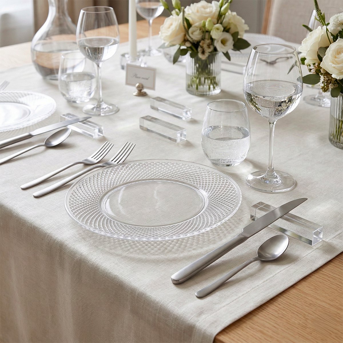 Doorzichtig bestek op een aangeklede tafel voor een bruiloft, alles in het wit