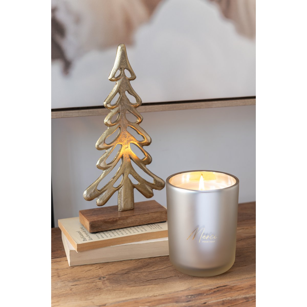 J-Line geurkaars beige glazen pot 10 cm Merci op een houten tafel met daarnaast houten en gouden decoratie