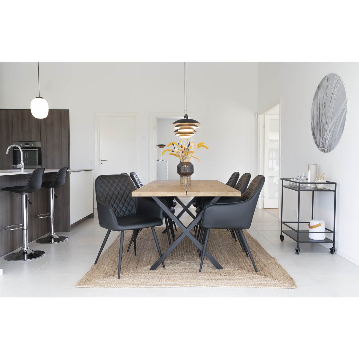 Jute vloerkleed naturel gevlochten Bombay onder een eettafel met zwarte stoelen en zwarte accenten