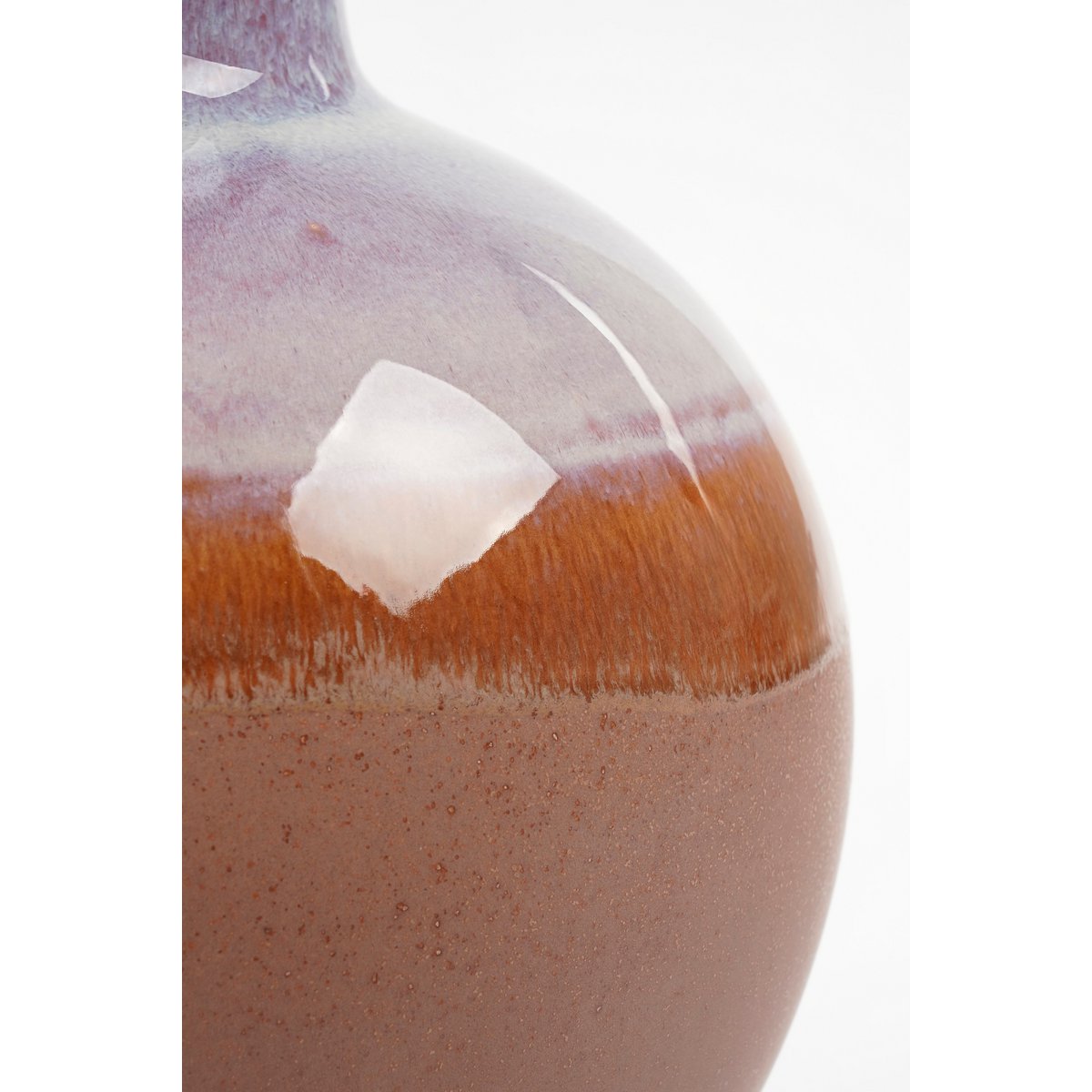 Closeup van een terracotta keramieken vaas met een warme, natuurlijke uitstraling. Perfect om gedroogde bloemen of takken in te plaatsen, maar ook prachtig als los decoratief object. De aardse tinten en matte afwerking brengen een rustieke en mediterrane sfeer in elk interieur.