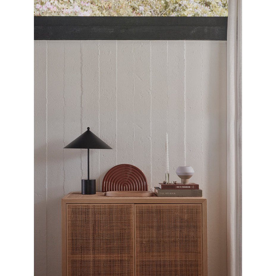 Keramisch regenboogvormig dienblad in glanzend bruin, stijlvol geplaatst op een houten dressoir naast een zwarte tafellamp en designboeken. Een elegant en modern woonaccessoire dat warmte en karakter toevoegt aan het interieur.