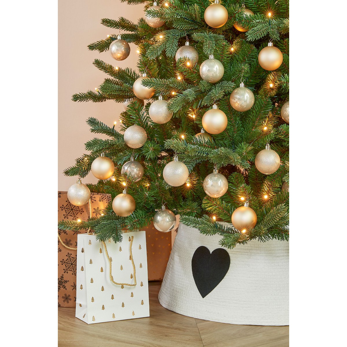 Witte kerstboommand met zwart hart onder versierde kerstboom – tijdloze en sfeervolle basis voor kerstdecoratie.