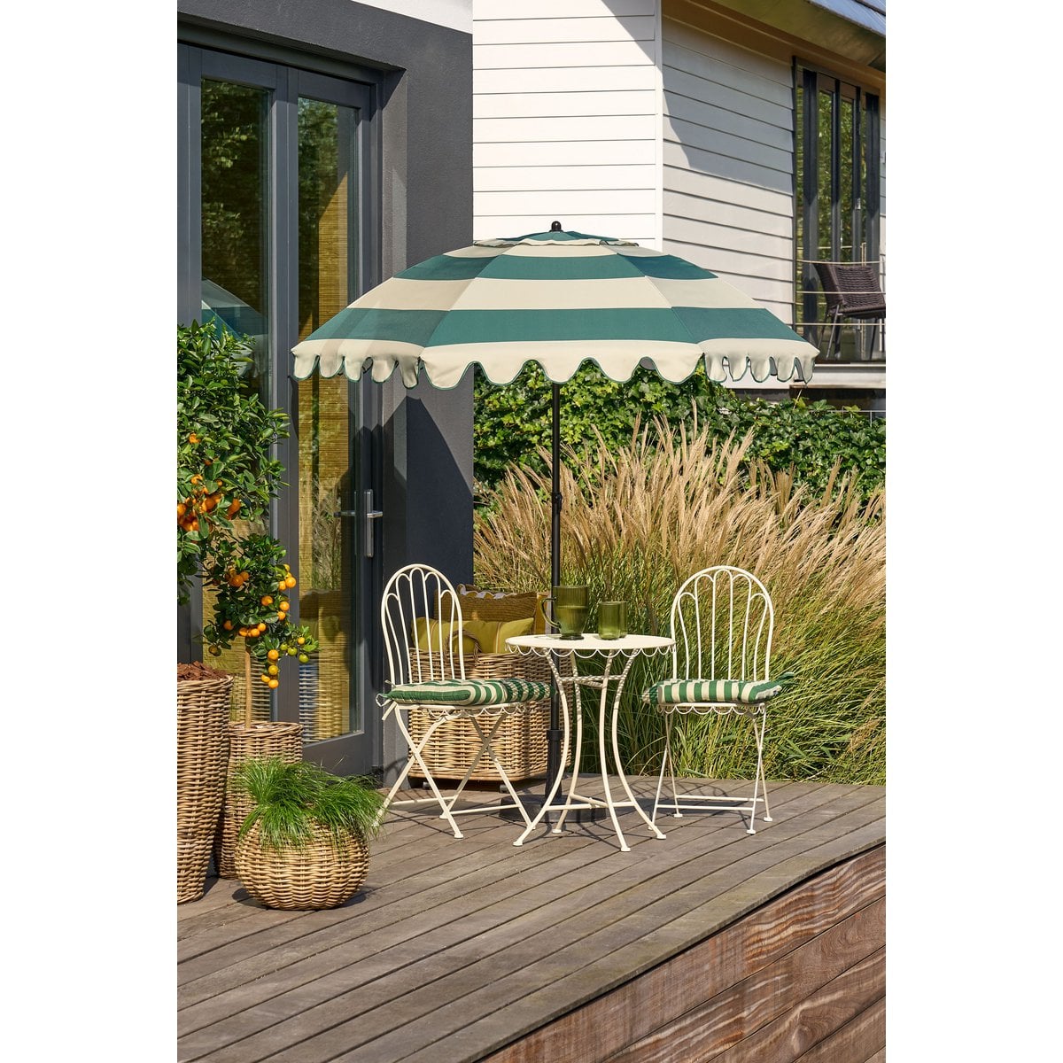 Parasol groen gestreept met kantelfunctie 195 cm op een terras met bijpassende stoelen en bistro tafeltje