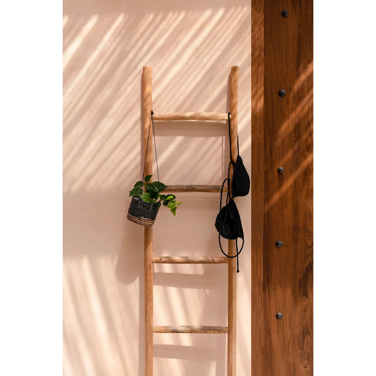 Plantenhanger bananenblad zwart 11 cm aan een houten ladder met groen plantje erin, met daarnaast een zwarte bikinitop