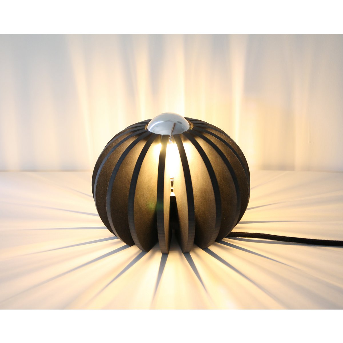 Wanneer de lamp aanstaat, creëert hij een prachtig lichteffect op tafel of muur. De open structuur zorgt voor een sfeervol samenspel van licht en schaduw.