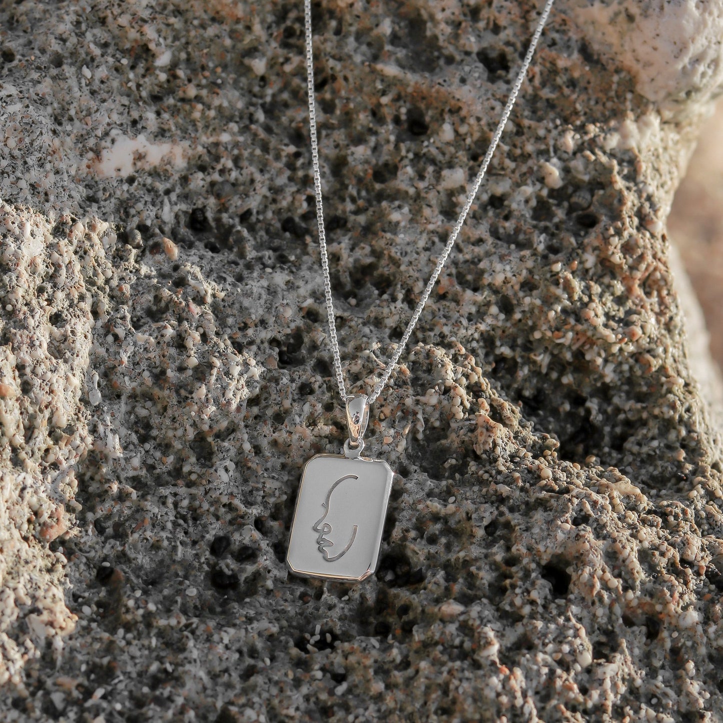 Sfeerfoto zilveren ketting met hanger op steen