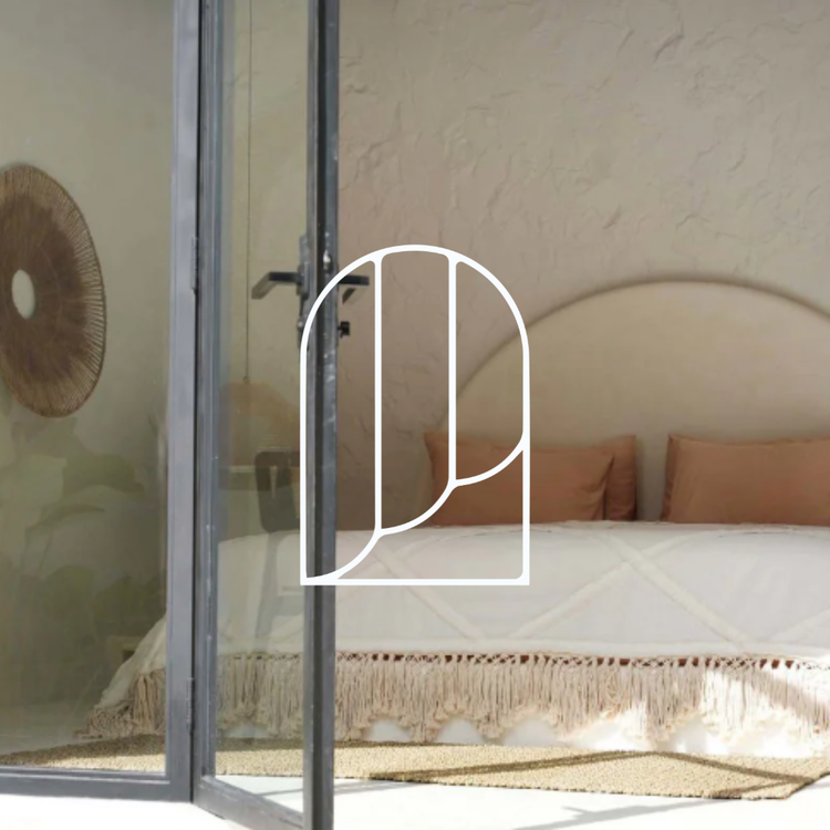 Afbeelding voor de collectie Bedspreien. Op de foto zie je een bed achter een open deur. Op het bed ligt een warme boho sprei.