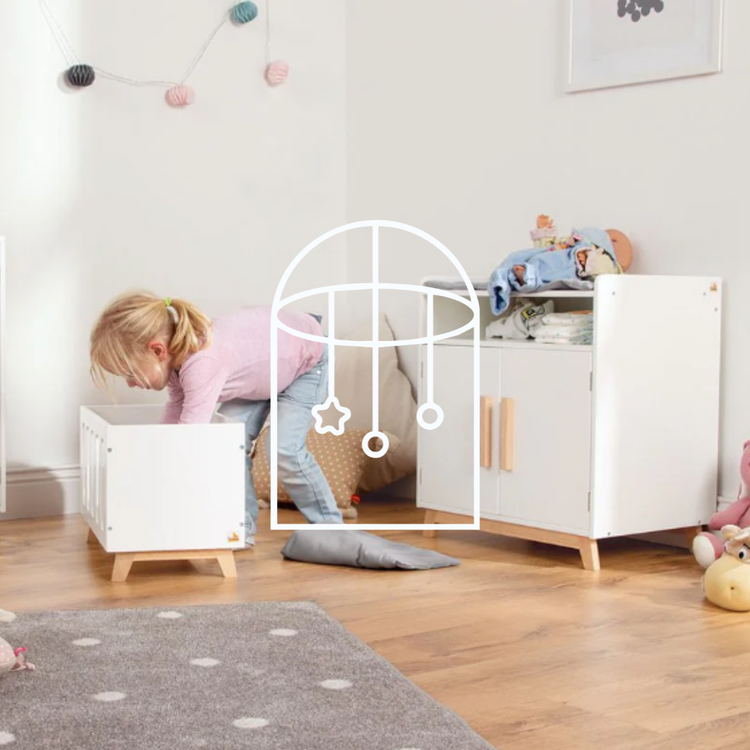 Afbeelding voor de collectie Poppen & Accessoires. Op de foto zie je een meisje die met haar poppen aan het spelen is in haar kinderkamer. Zo staat er een poppen-ledikant en een kastje om een pop op te verschonen.