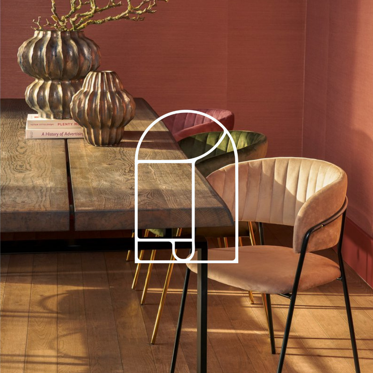 Afbeelding voor de collectie Stoelen. Op de foto zie je een houten tafel met wat vazen, en meerdere kleuren fluwelen stoelen voor een rode muur.