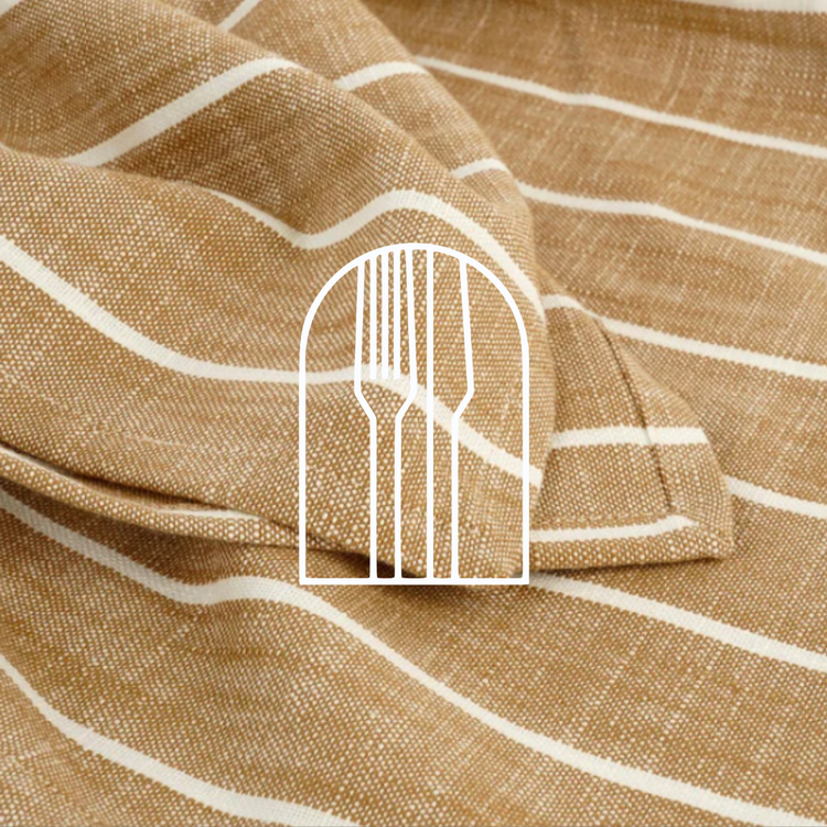 Afbeelding voor de collectie afbeelding Tafellinnen. Op de foto zie je een beige katoenen tafelkleed met witte strepen.