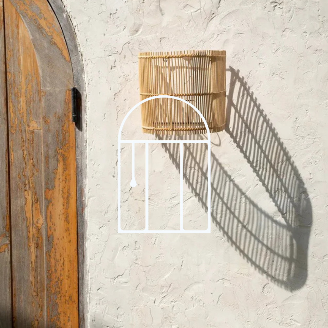 Afbeelding voor de collectie Wandlampen. Op de foto zie je een rotan wandlamp aan een buitenmuur hangen.