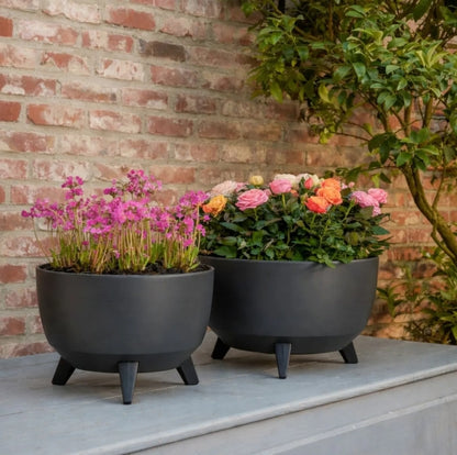 2 potten voor buiten antraciet op poten Doppio, gevuld met vrolijke bloemen