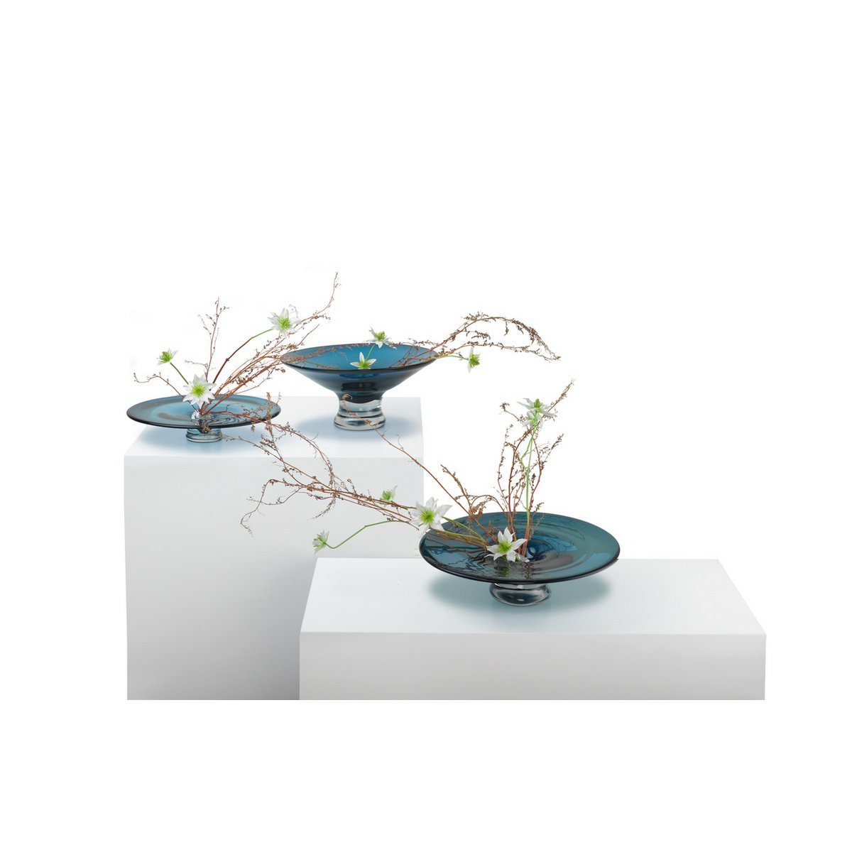 3 glazen taartplateau inktblauw rond 32 cm Alain op witte kastjes, met stengels van bloemen