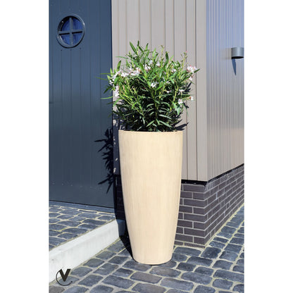 Beige fiberstone plantenbak Java in een grijze moderne tuin met planten erin