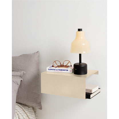 Beige boxshelf gebruikt als minimalistisch nachtkastje in modern interieur