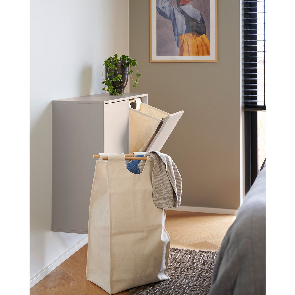 Wand-wasbox gemonteerd naast een waszak in slaapkamer