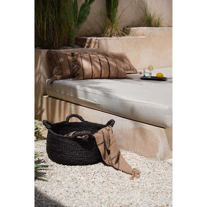 Plaid met strepen op beige loungebank – bohemian woonaccessoire voor binnen en buiten.
