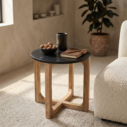 Bijzettafel marmer zwart hout rond 50x50 cm naast een bank met een schaal met noten, een boek en een vaasje