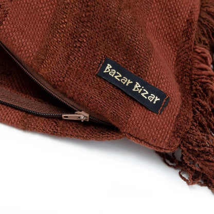 Detail close-up van de fluwelen stof en franjes van de bordeaux kussenhoes