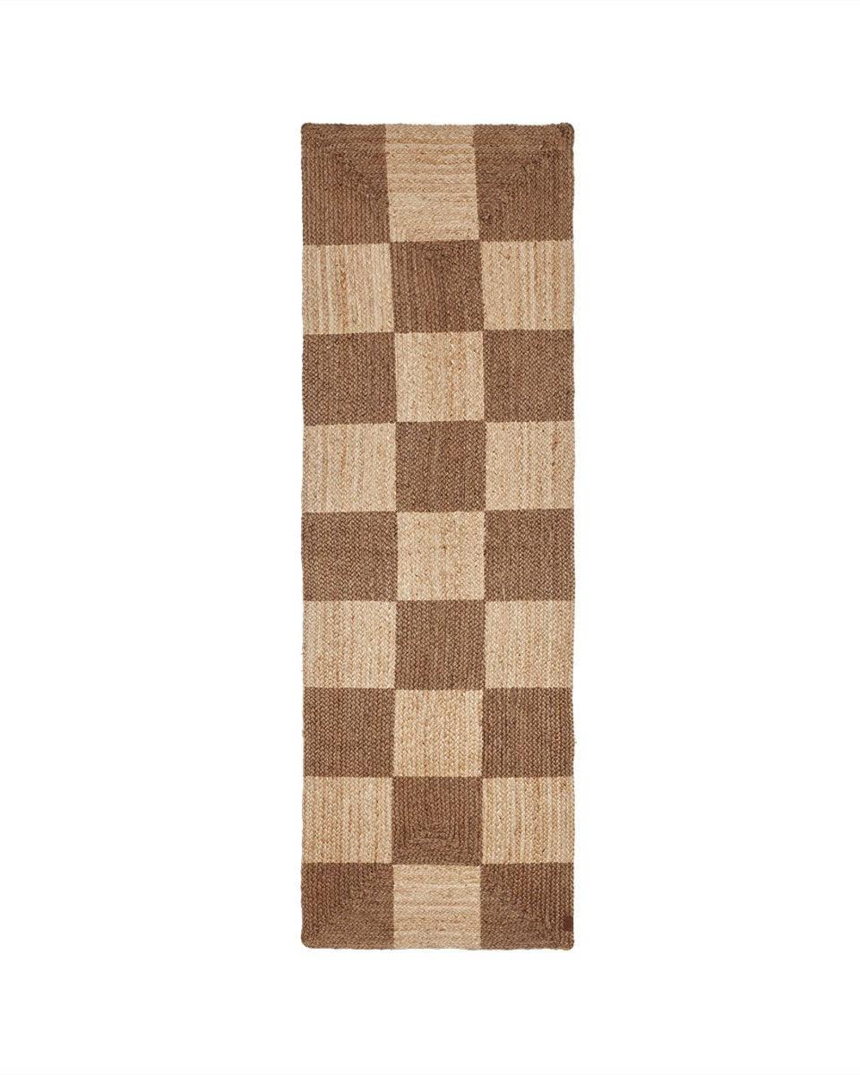 Een stijlvolle juten loper met een speels ruitpatroon in natuurlijke tinten. Handgeweven en tijdloos — perfect om warmte en structuur toe te voegen aan elke ruimte.

