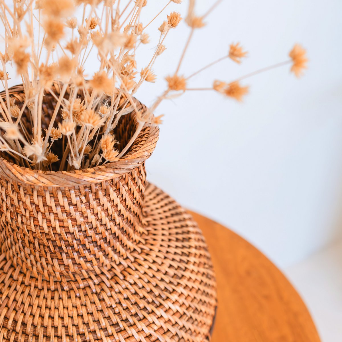 Detail van de Rotan vaas bruin 22 cm voor bloemen Kamari met droogbloemen erin op houten tafel