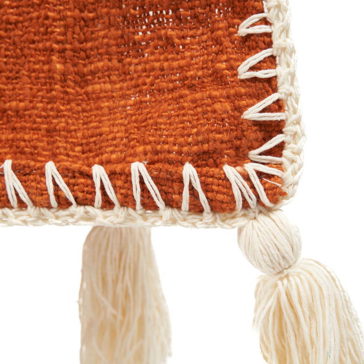 Detail van de geweven textuur en franjes van de katoenen terracotta bedsprei