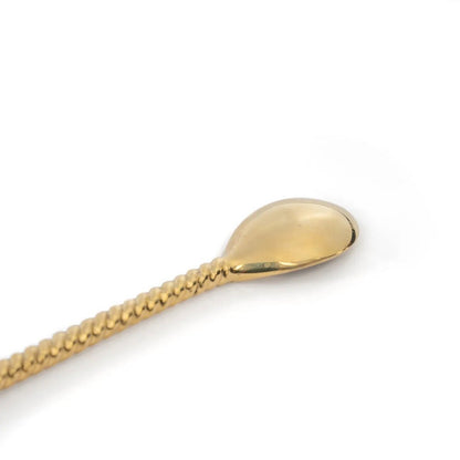 Detail van het uiteinde van de lange lepel goud met palmboom 