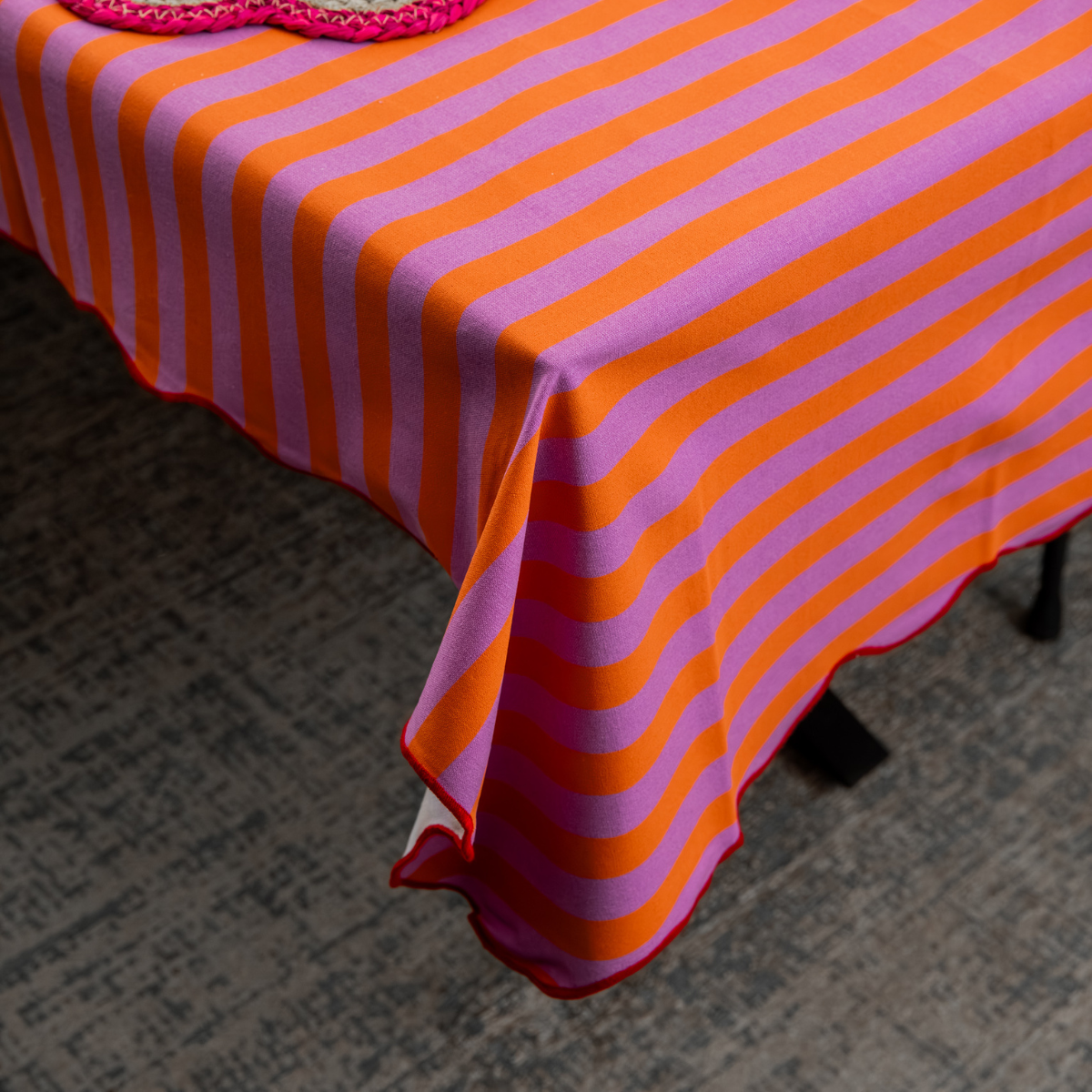 Detailopname van een gedekte tafel met het oranje-roze tafelkleed