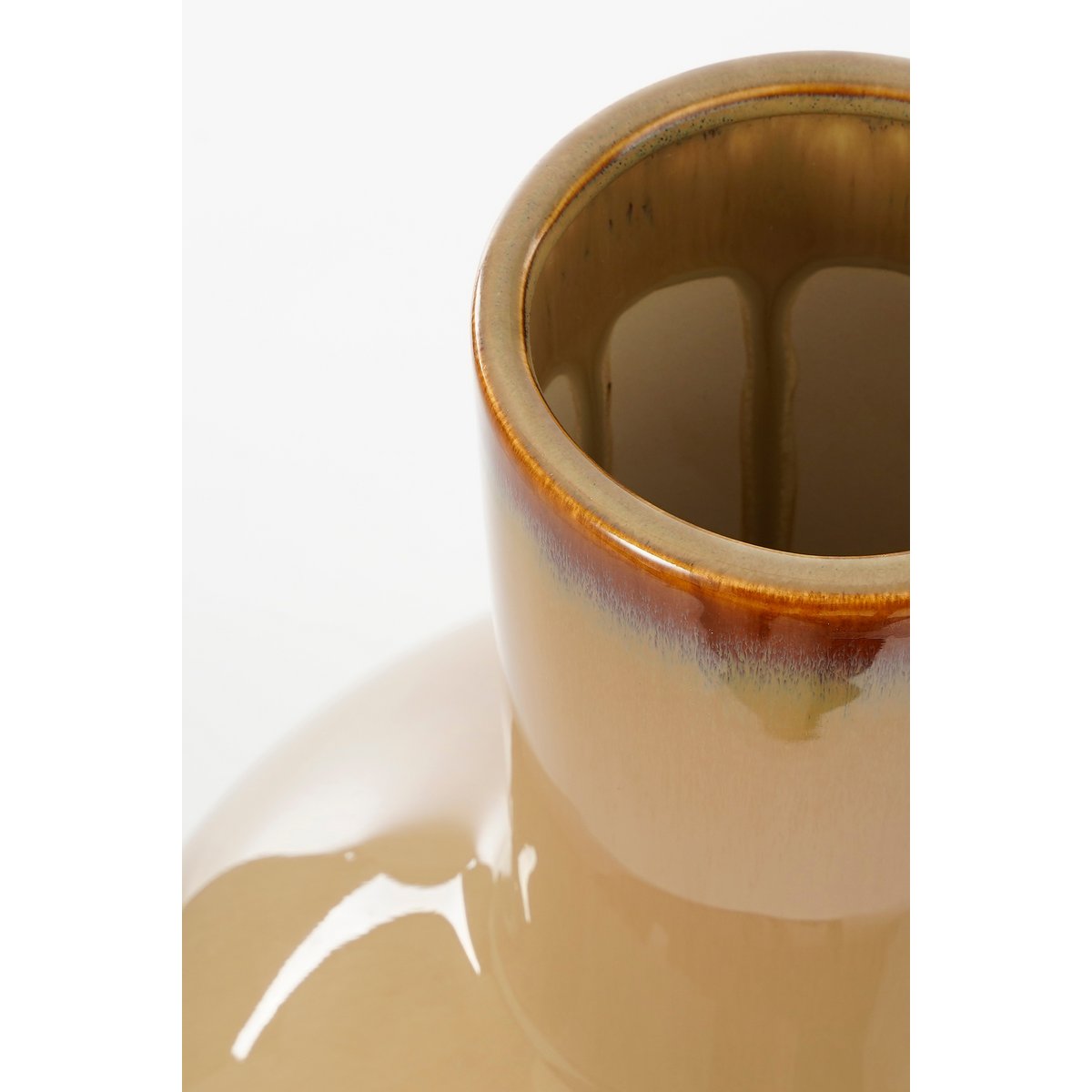 Closeup van een beige keramieken vaas met een warme, natuurlijke uitstraling. Perfect om gedroogde bloemen of takken in te plaatsen, maar ook prachtig als los decoratief object. De aardse tinten en matte afwerking brengen een rustieke en mediterrane sfeer in elk interieur.