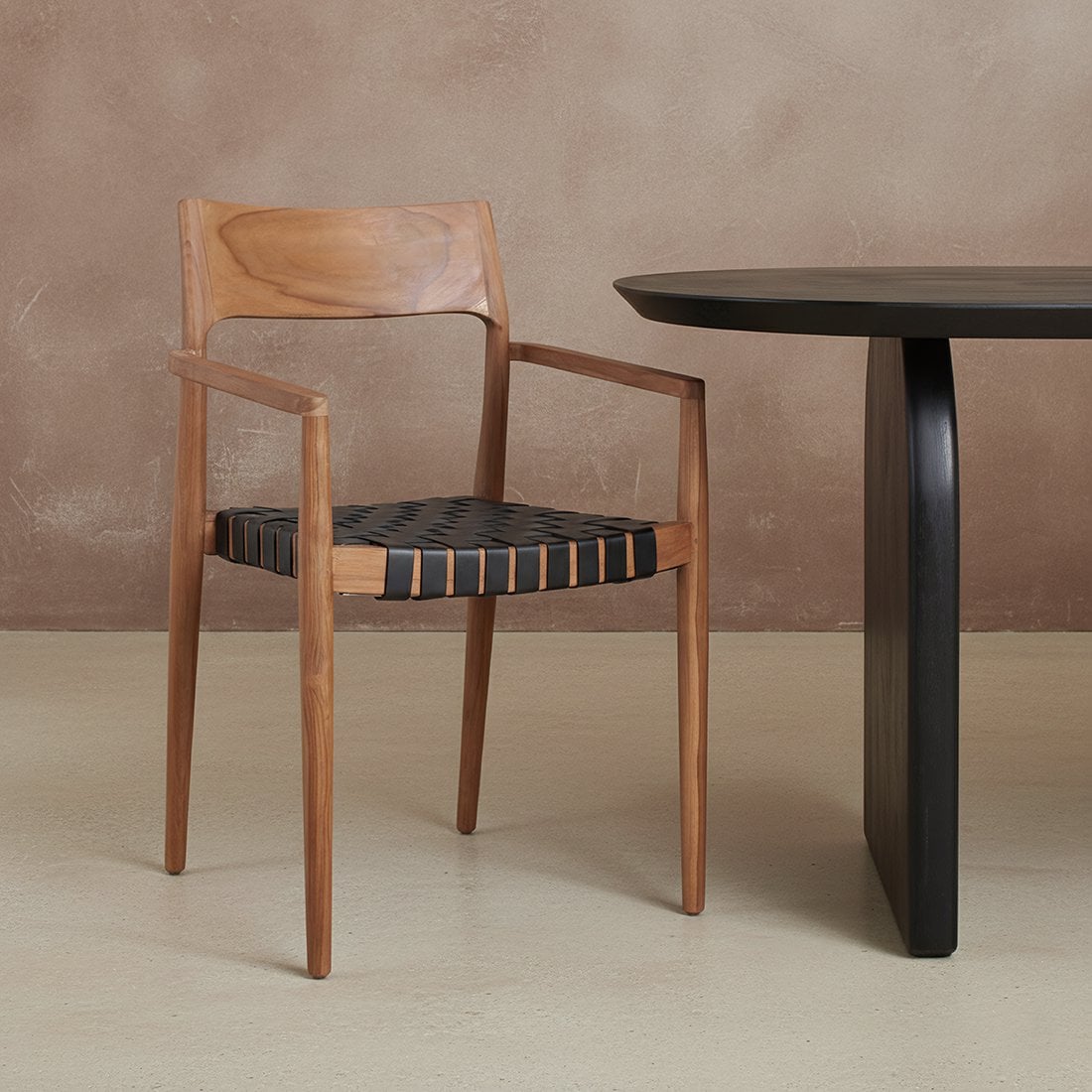 Eetkamerstoel met armleuning hout zwart leer Freya naast zwarte houten eettafel