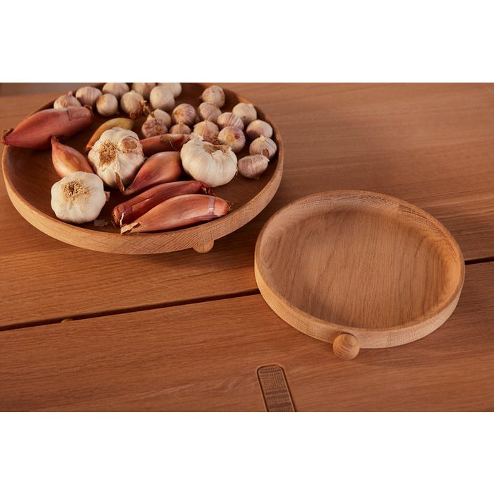 Eiken dienblad rond naturel 22x20 cm Inka op houten tafel naast grotere dienblad met groentes erop