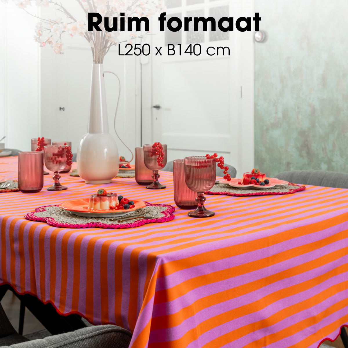 Gedekte tafel met het oranje-roze tafelkleed en bijpassend servies
