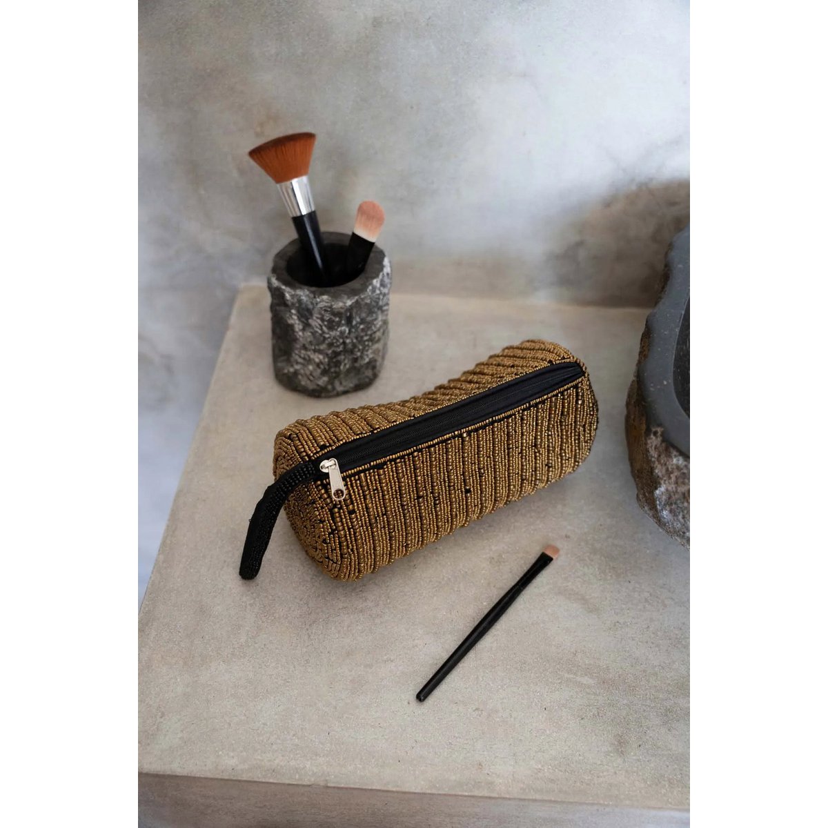 Gouden etui The Pencil Case gestyled op een aanrecht met make up kwastjes en borstels