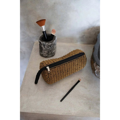 Gouden etui The Pencil Case gestyled op een aanrecht met make up kwastjes en borstels