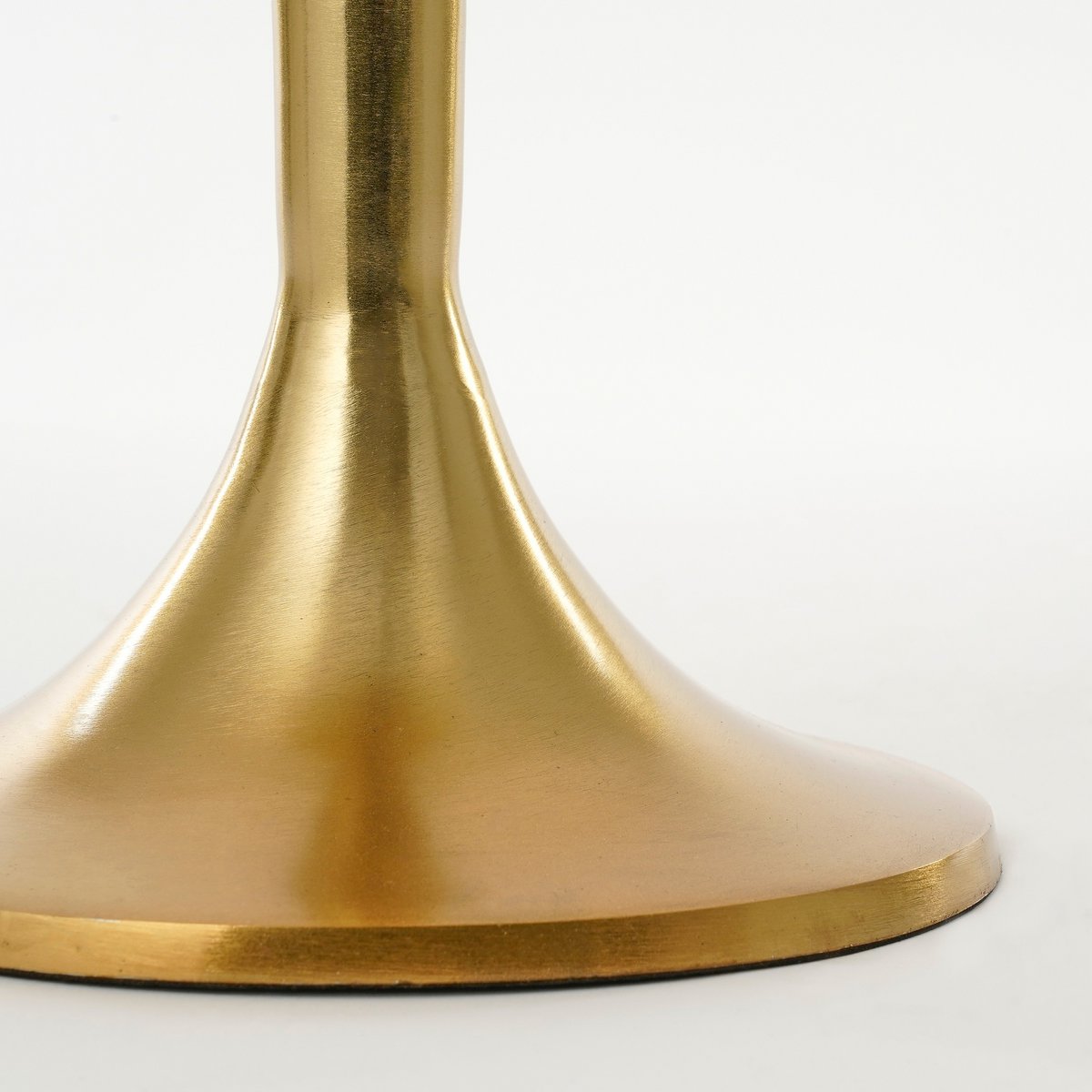 Detailfoto van de strikvorm langs de poot van de gouden tafel.