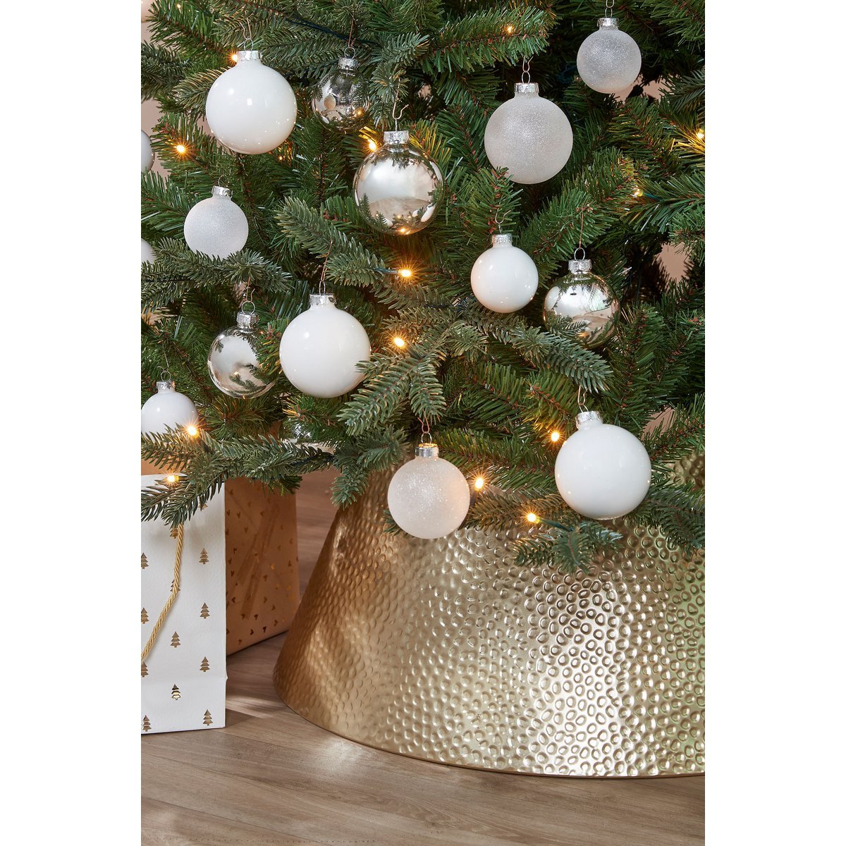 Gouden kerstboommand onder versierde boom – chique en moderne basis die elke kerstboom laat stralen.