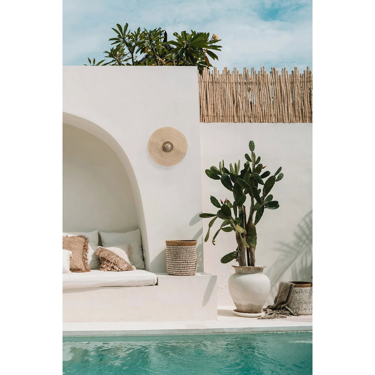 Gras wandlamp messing Let's Groove aan een witte muur bij een zwembad en witte boho meubilair
