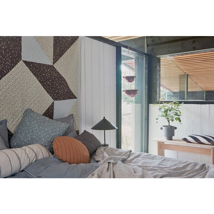 Een rustige blikvanger in een natuurlijke setting. De matte grijstint past moeiteloos bij warme houtsoorten en zachte stoffen, perfect voor een serene sfeer in de slaapkamer.
