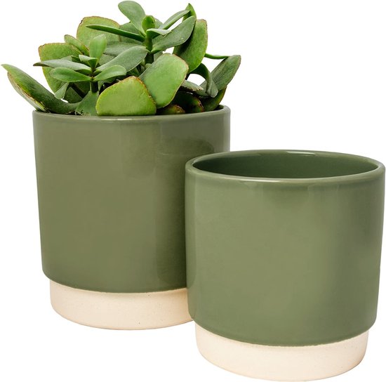 Groene geglazuurde keramieken bloempot naast een andere groene bloempot met plantje erin