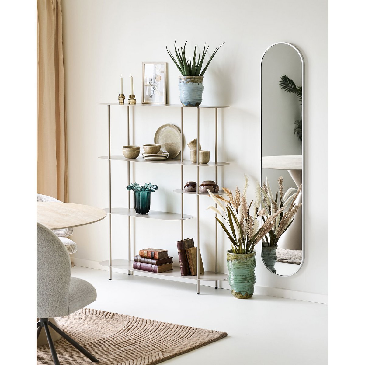 Groene glazen vaas gestyled in kast met accessoires