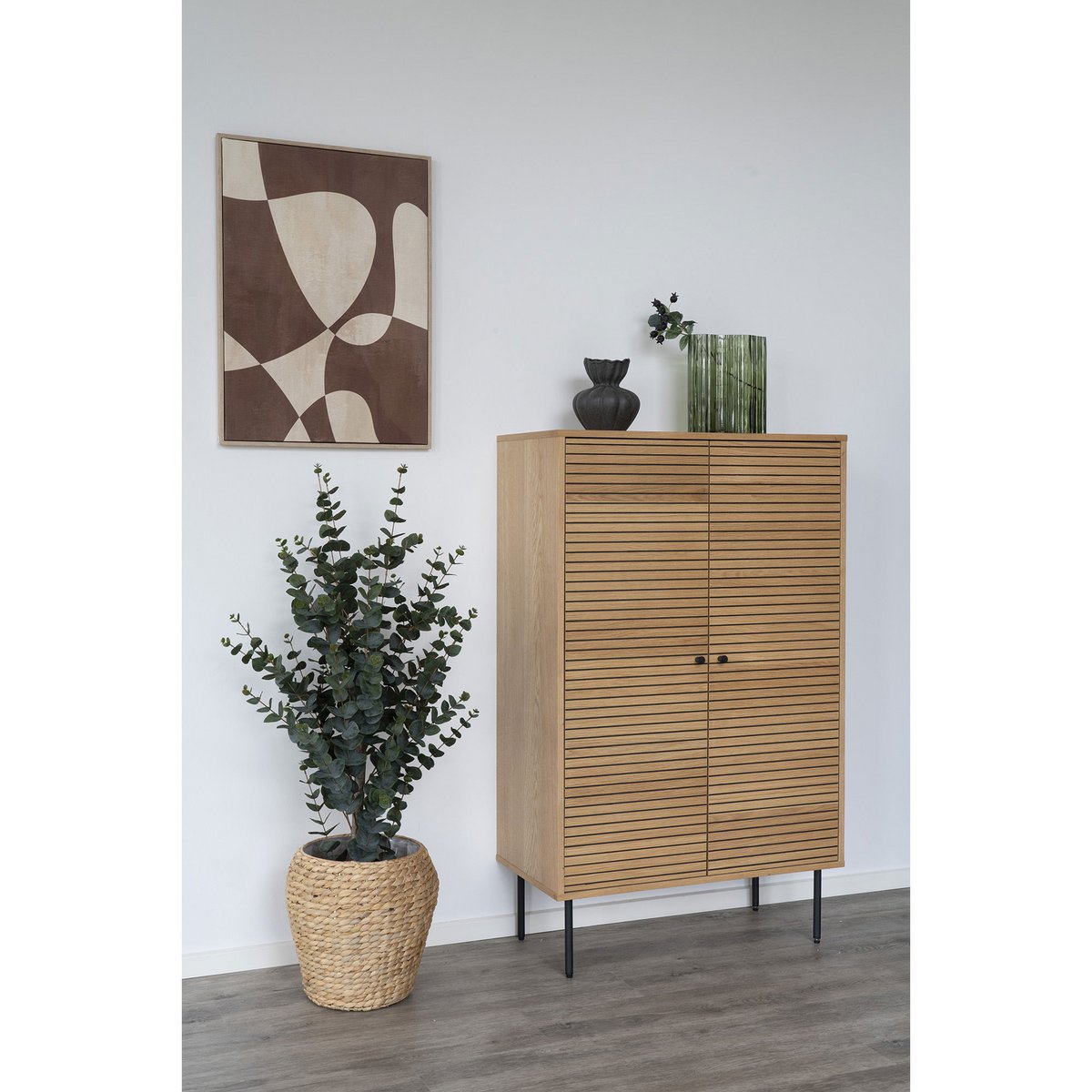 Groene glazen vaas in modern interieur op dressoir