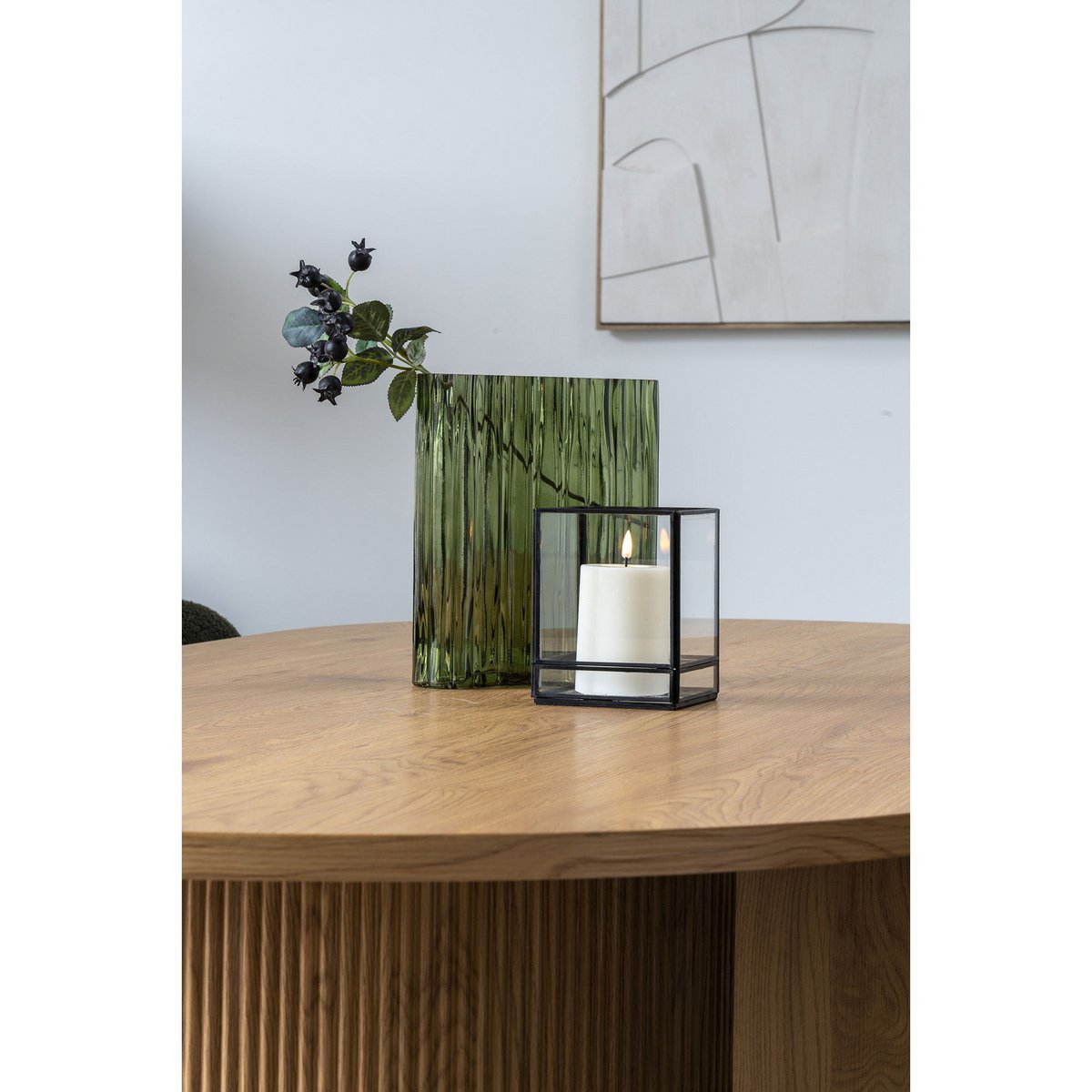 Groene vaas gestyled op tafel met accessoires