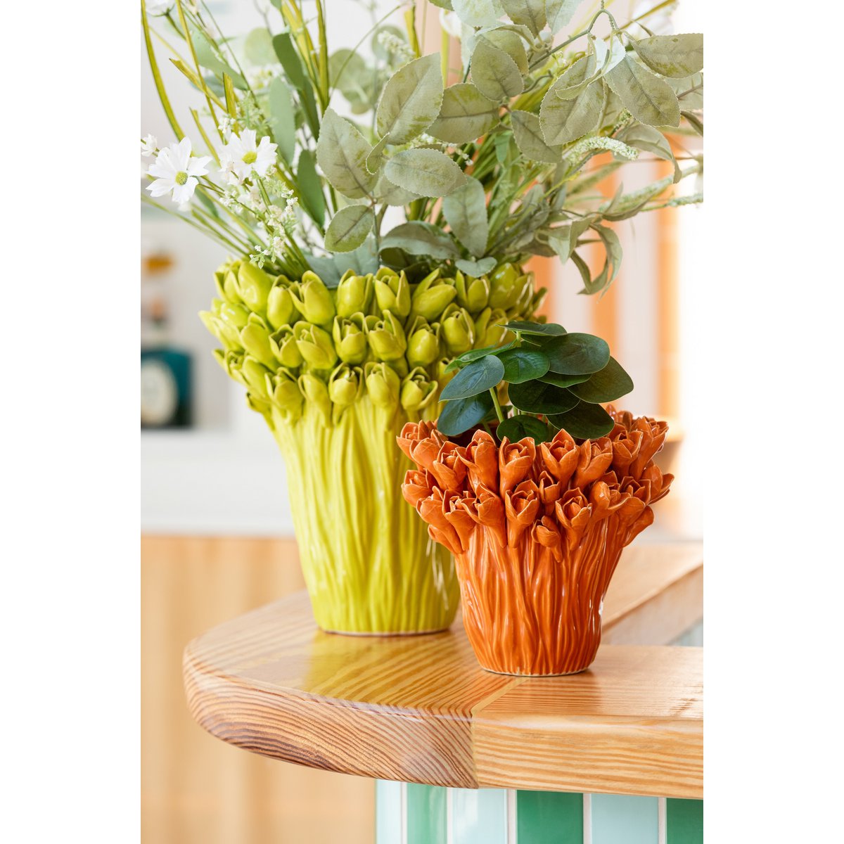 Groene vaas met bloemen op tafel met woonaccessoires