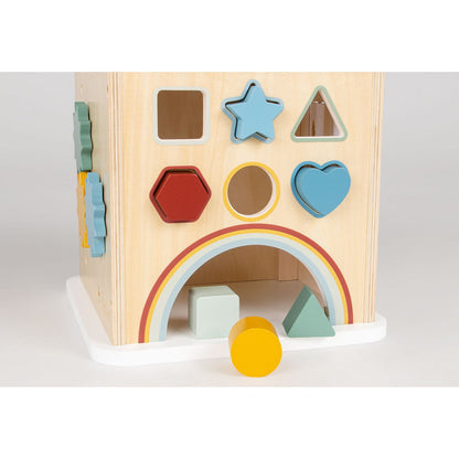 Close-up van houten speelkubus met vrolijke vormen, tandwielen en regenboogboog.