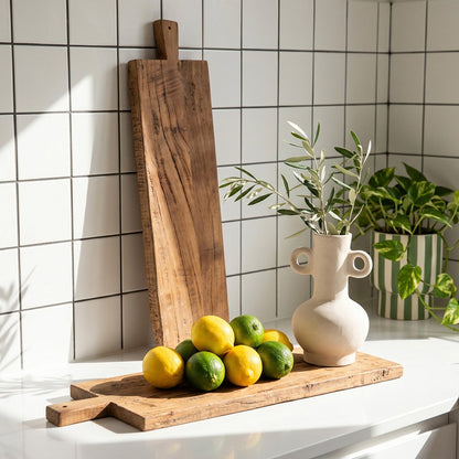 Houten borrelplank naturel 90 cm Farmwood in een keuken op wit aanrecht met vazen met planten en fruit