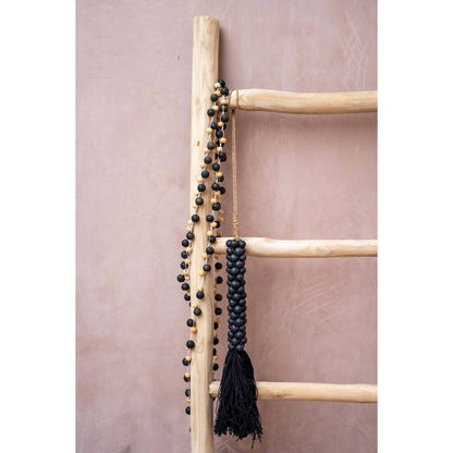 Lange houten ketting Canggu hangend aan wandrek