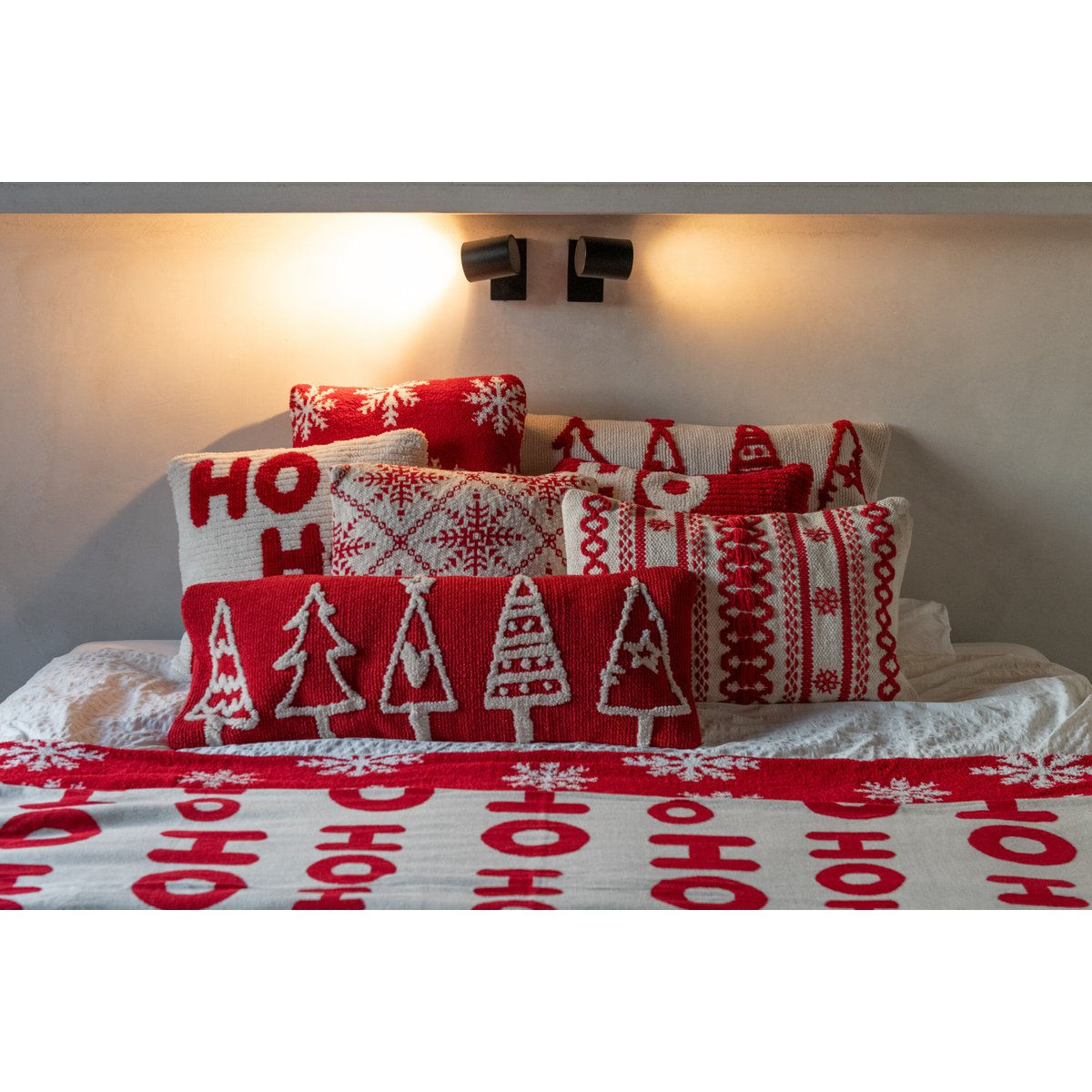 J-Line kerstkussen rood en wit met sneeuwvlokken decoratief op bed met andere soorten kerstkussens en een kerst sprei