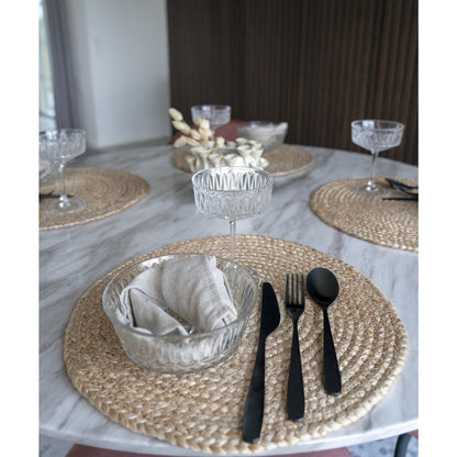 Jute placemat rond naturel 38 cm set van 4 Bombay op een gedekte tafel met zwart bestek, een cocktail en klein glazen schaaltje