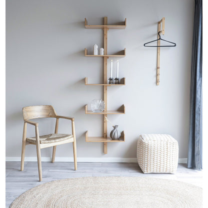 Ovaal jute vloerkleed onder houten wandplanken in modern interieur
